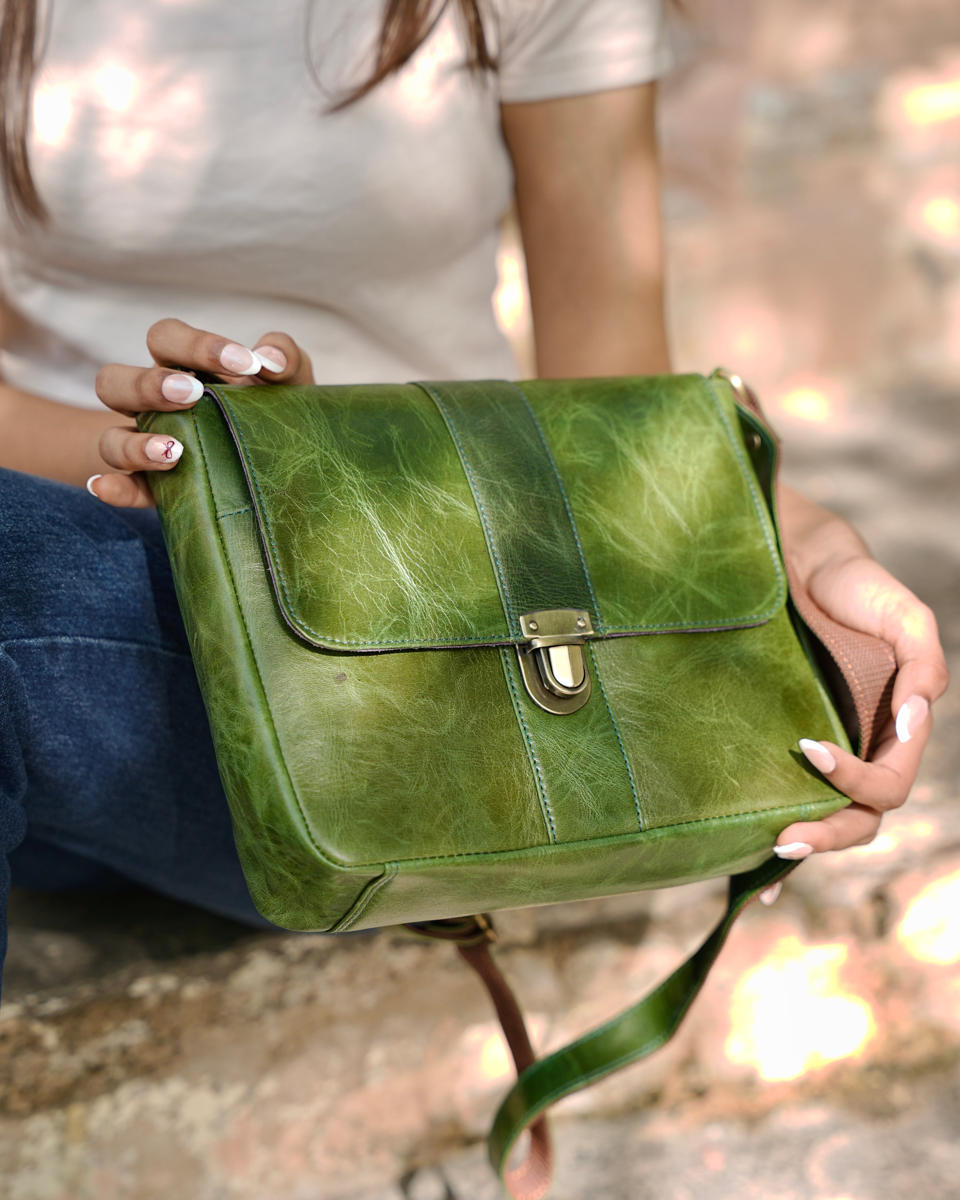 woman holding a green sling bag with multiple compartments and utility and aesthetic