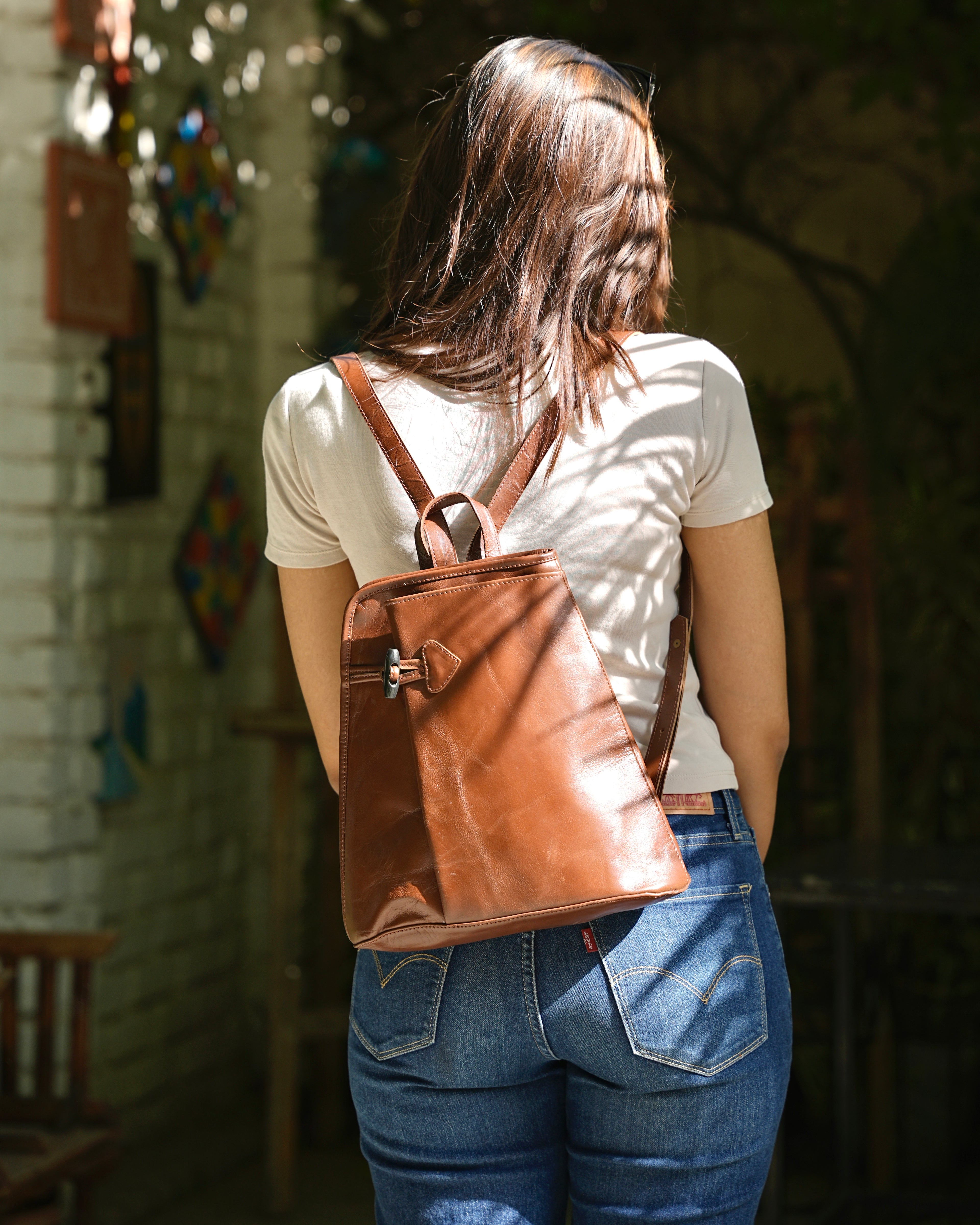 Person wearing a brown buffalo leather backpack with a aesthetic vibe 100% leather
