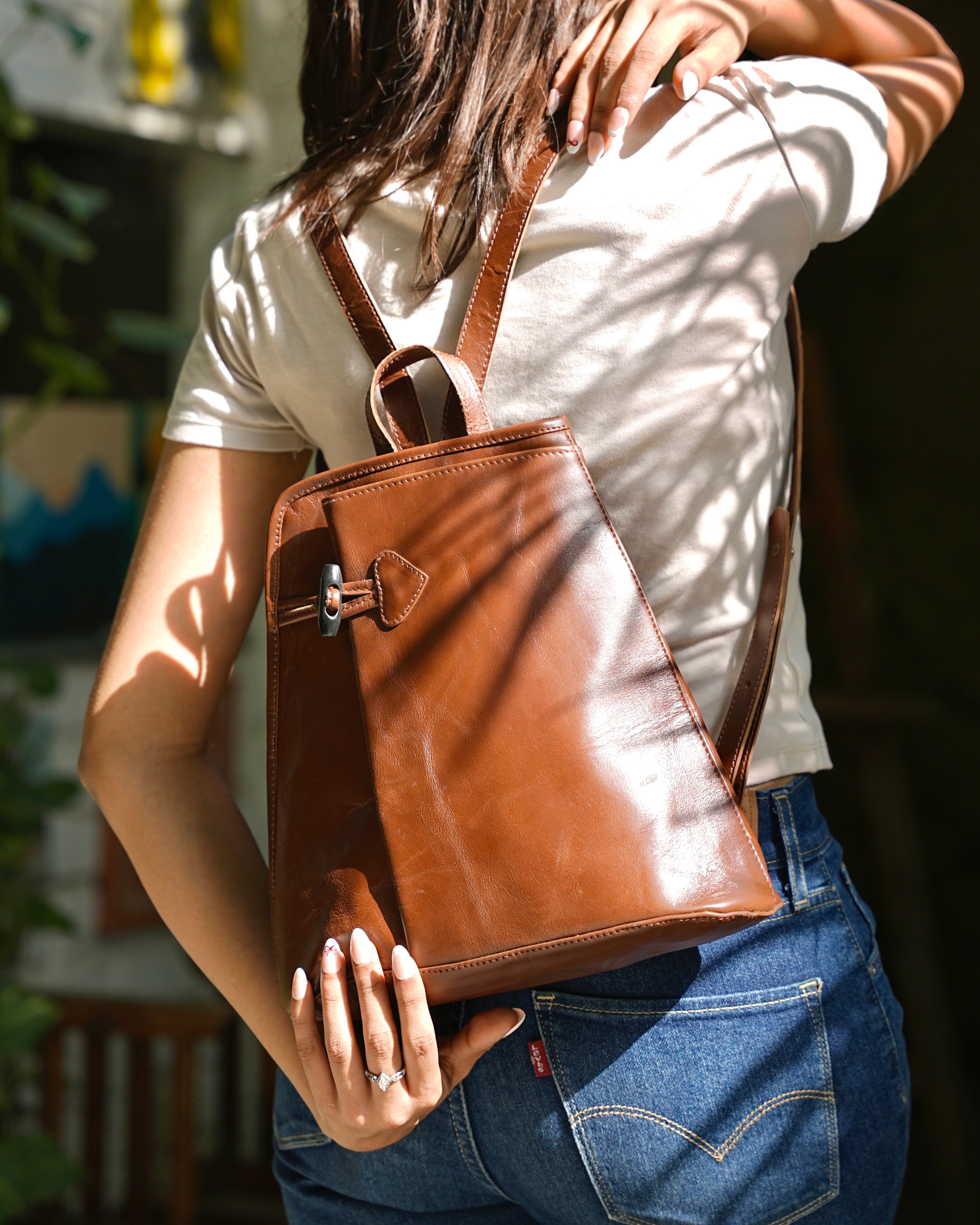 Person wearing a brown buffalo leather backpack with a aesthetic vibe 100% leather